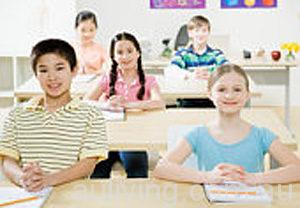 Five pupils (8-11) sitting at desks with hands clasped, in classroom