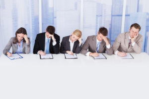 Group of tired corporate personnel officers at table in office