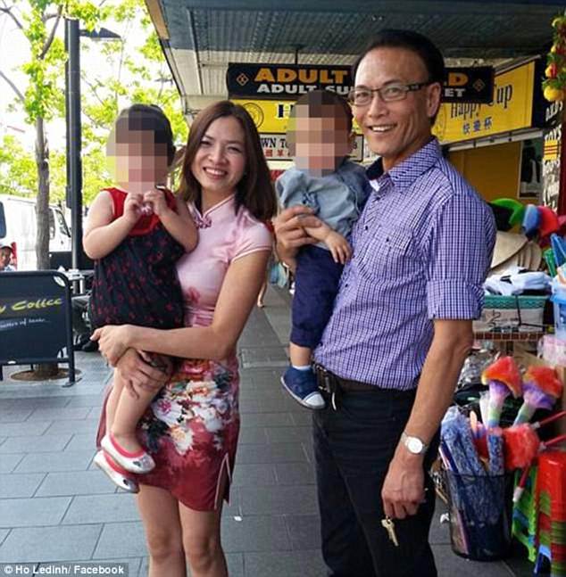 Mr Ledinh stands out the front of the Happy Cup cafe with his wife and two young children