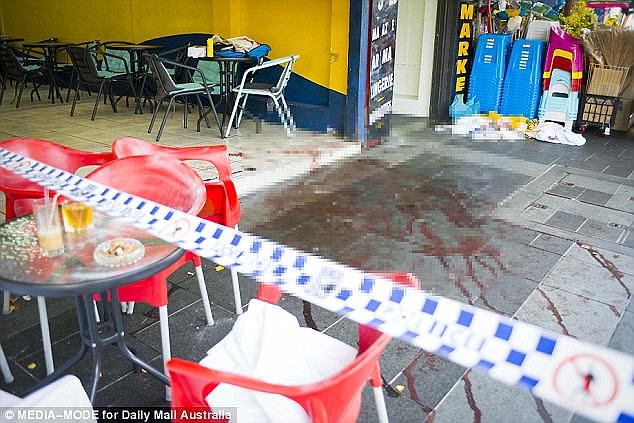 The footpath outside the Happy Cup cafe lays splattered with blood following the shooting