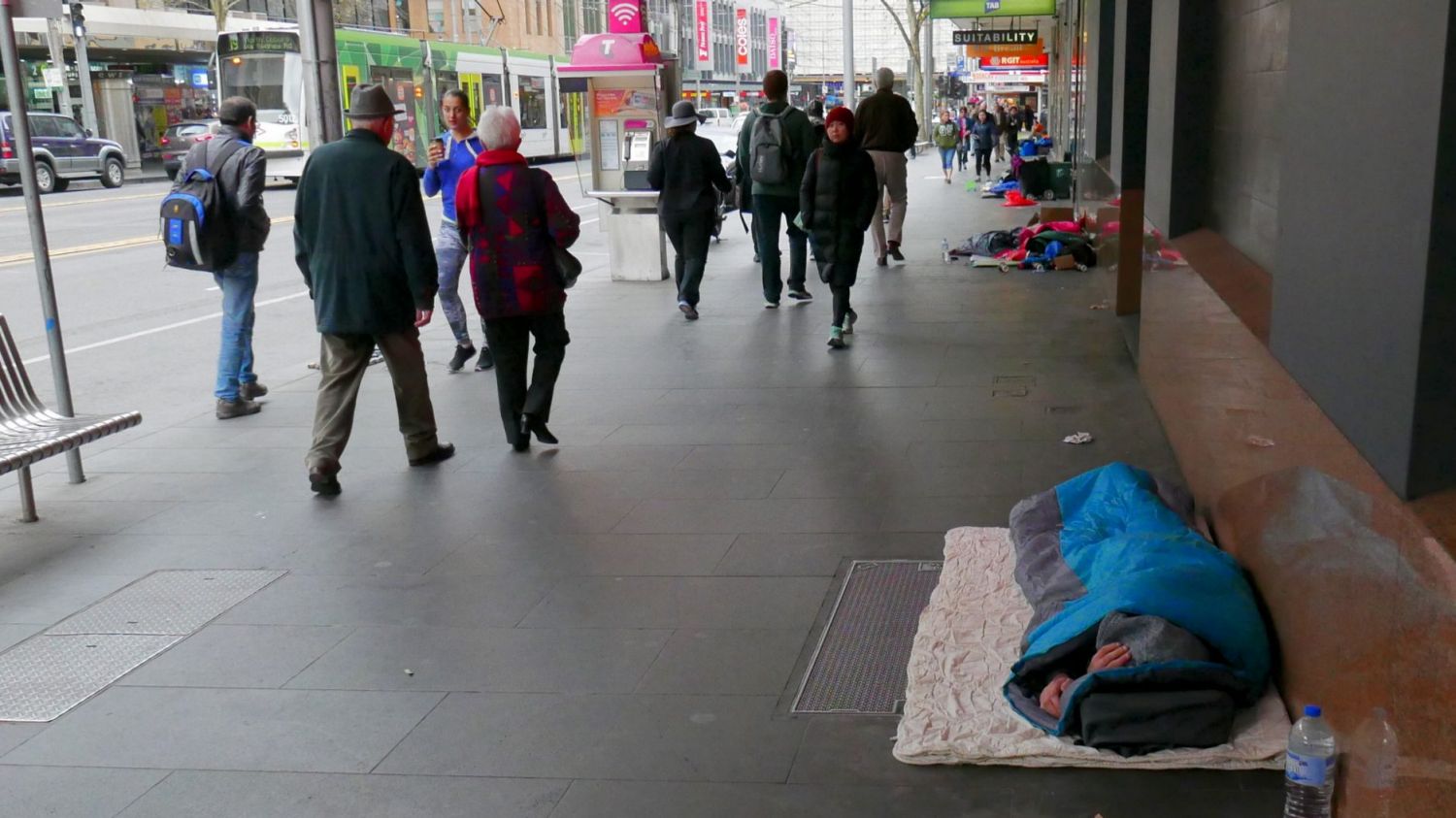 Homeless people sleep on the footpath in Elizabeth Street in Melbourne's CBD.