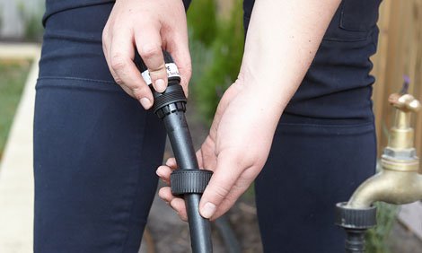 Person attaching whole system to the garden tap