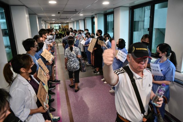 瑪麗醫院的醫護人員在午休時間組成一條人鏈支持「反送中」運動。（ANTHONY WALLACE/AFP/Getty Images）