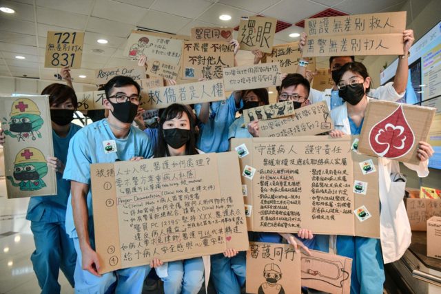 瑪麗醫院的醫護人員在午休時間組成一條人鏈支持「反送中」運動。（ANTHONY WALLACE/AFP/Getty Images）