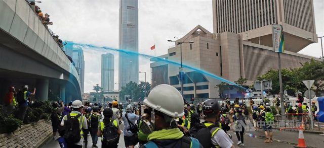 政府水炮车向示威人群喷射颜色水（图片来源：中央社）