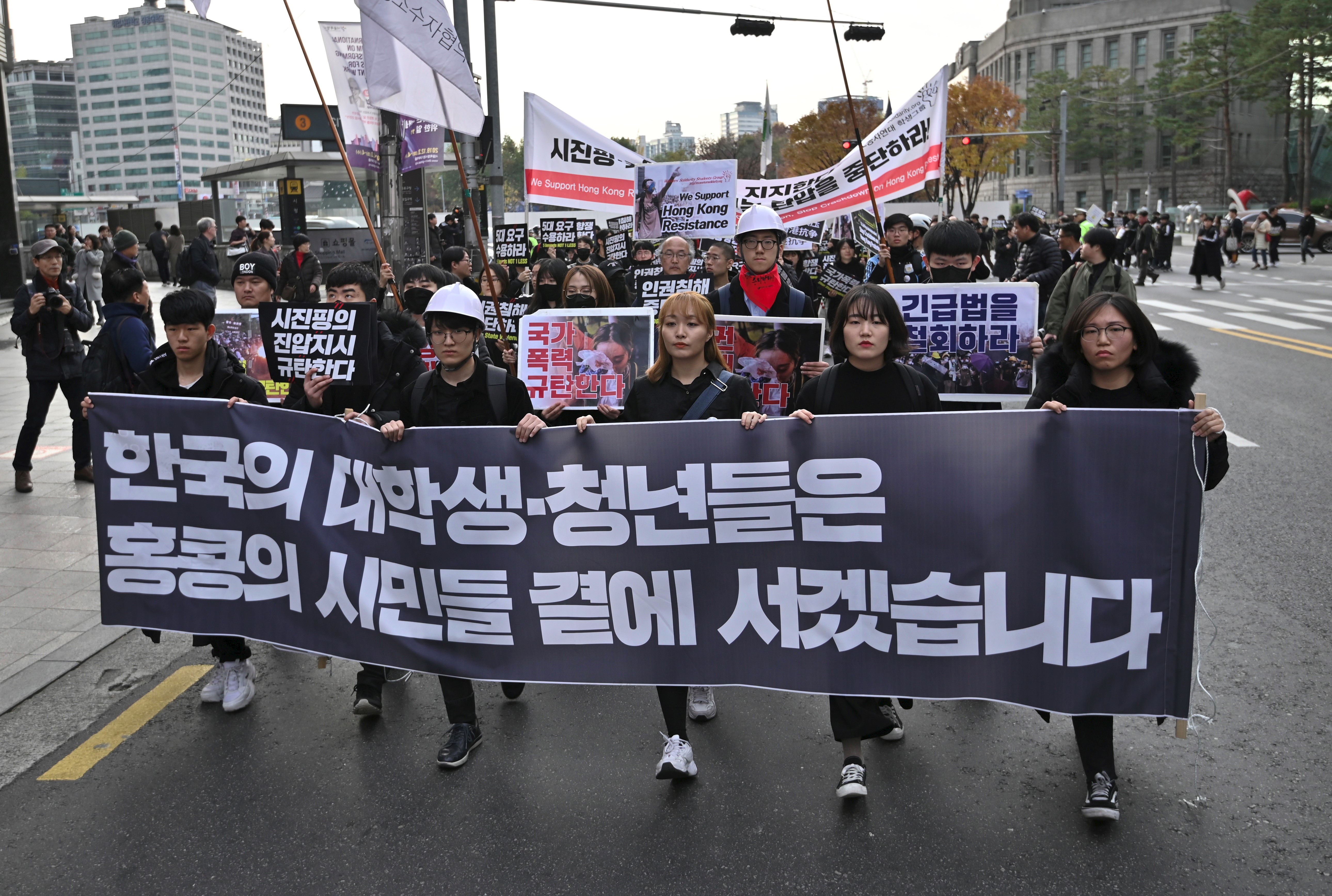2019年11月23日，韓國抗議者舉著標語牌，向中國大使館遊行
