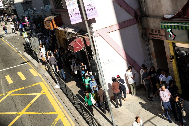 大量香港市民排在投票站外等待投票。（圖片來源：中央社）