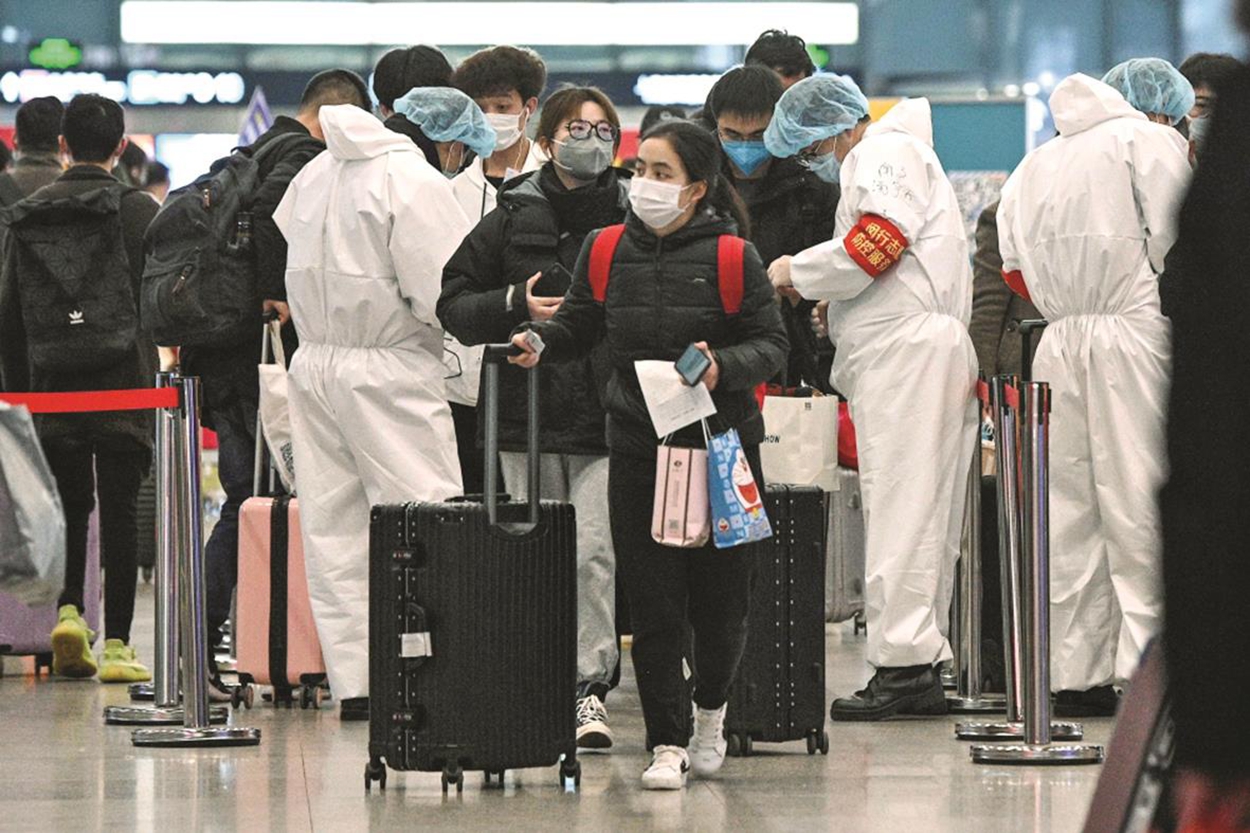 戴著防護口罩的乘客到達上海虹橋火車站